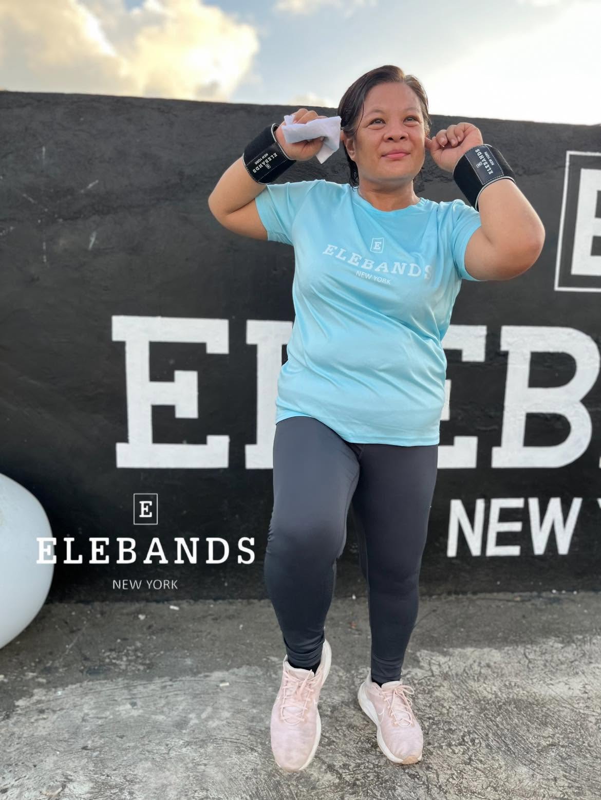 Woman exercising outdoors while wearing EleBands wrist weights