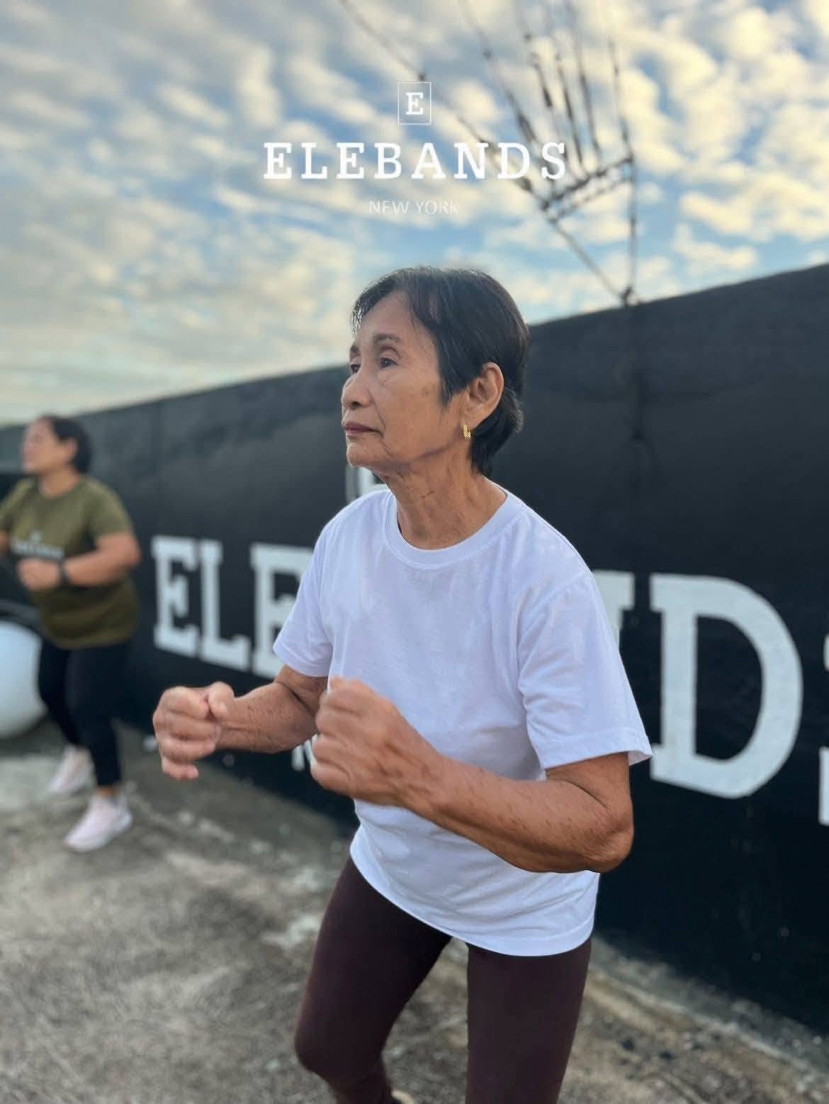 Senior woman exercising at an EleBands outdoor fitness event