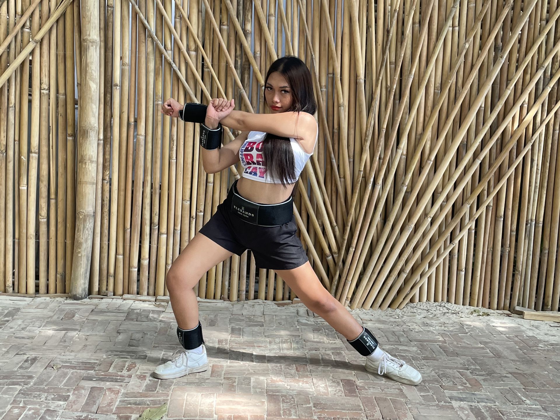 Woman performing a side-lunge cardio exercise with EleBands weights